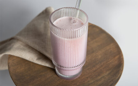 berry smoothie meal replacement in a glass with a straw