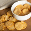 bbq popped chips in a white bowl and scattered on table