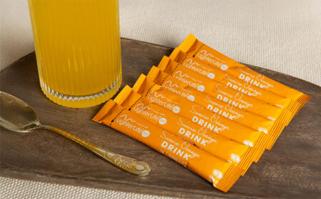 7 sunrise orange drink mix sachets next to a glass of drink